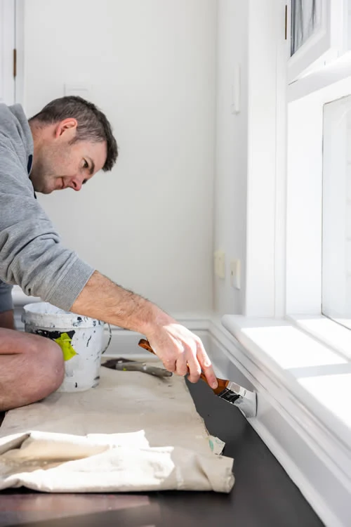 Painting baseboards in Adelaide house